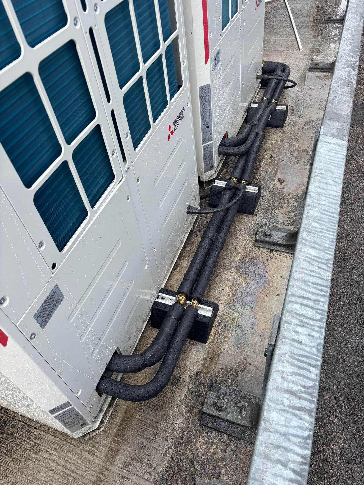 Mitsubishi Electric outdoor units with insulated pipework run along supports