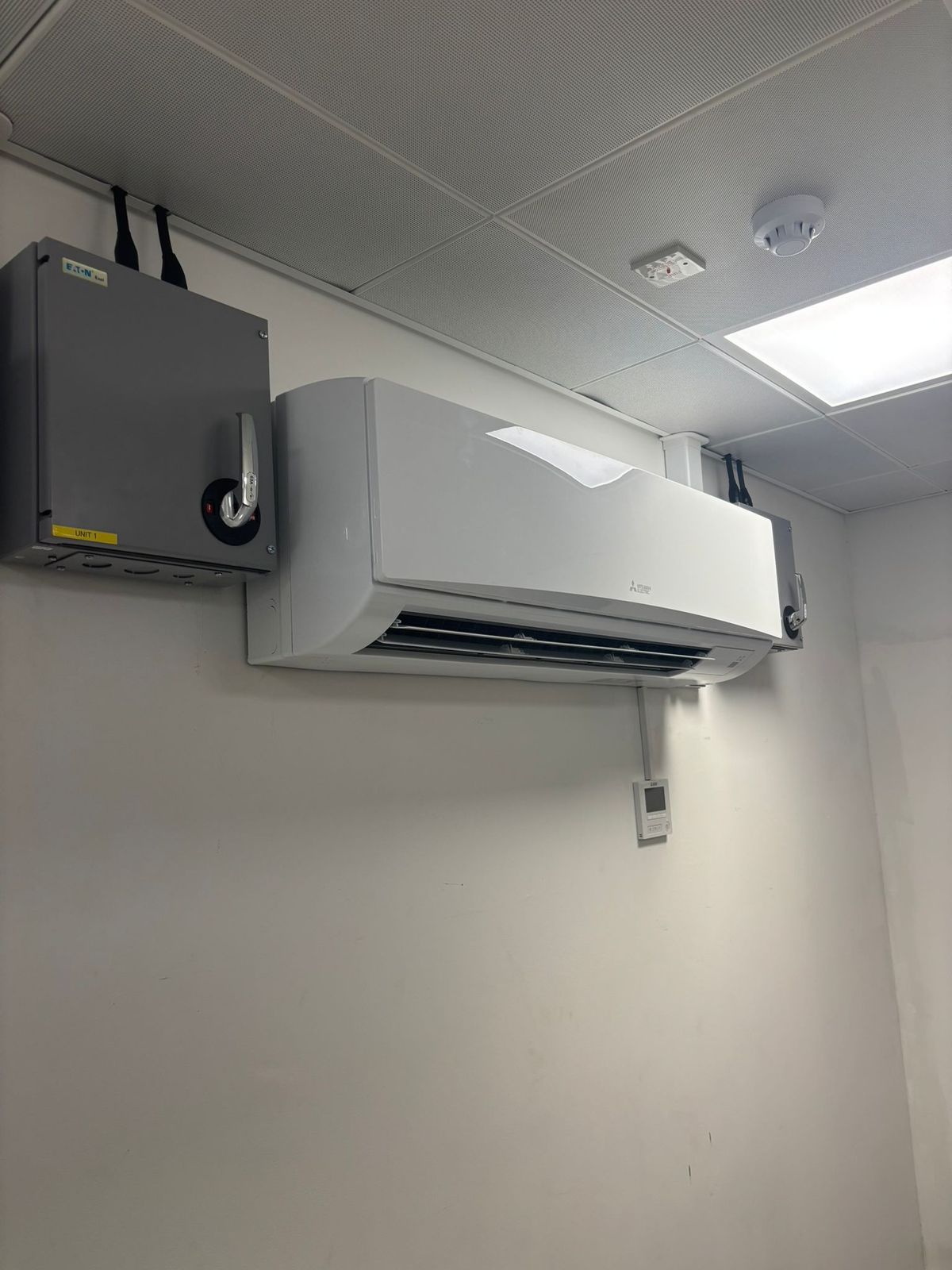 Wall-mounted air conditioning unit with an isolator switch fitted below it
