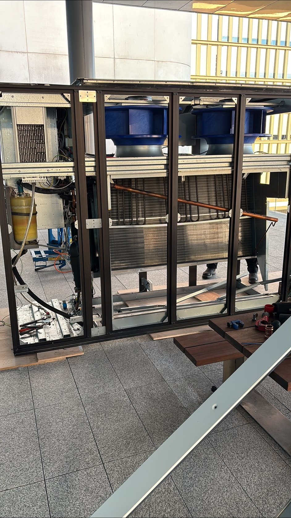 Close control units with their side panels off, showing the blue fans and coils, during installation in Cardiff